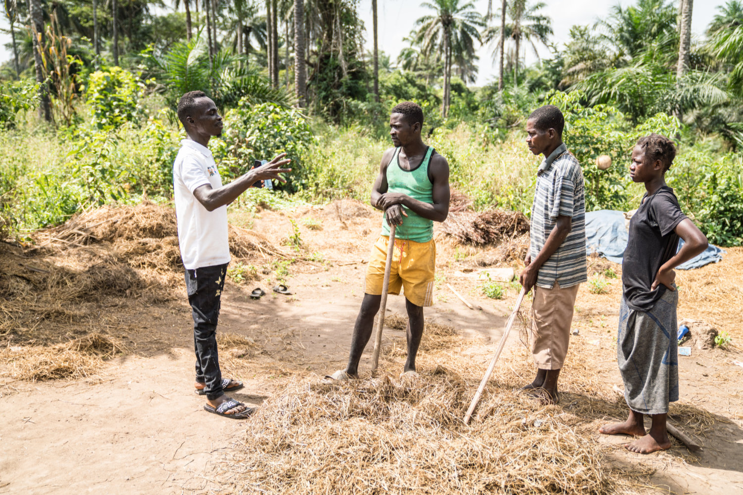 Community mobiliser Jeremiah (left) speaks with rice farmers in Sierra Leone