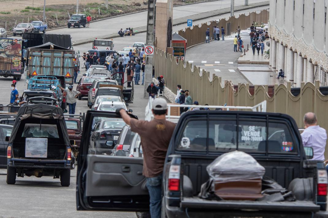 People transporting the remains of deceased loved ones wait in a slow moving line outside Jardines de la Esperanza Cemetery to hold burials in Guayaquil, Ecuador, April 6, 2020.