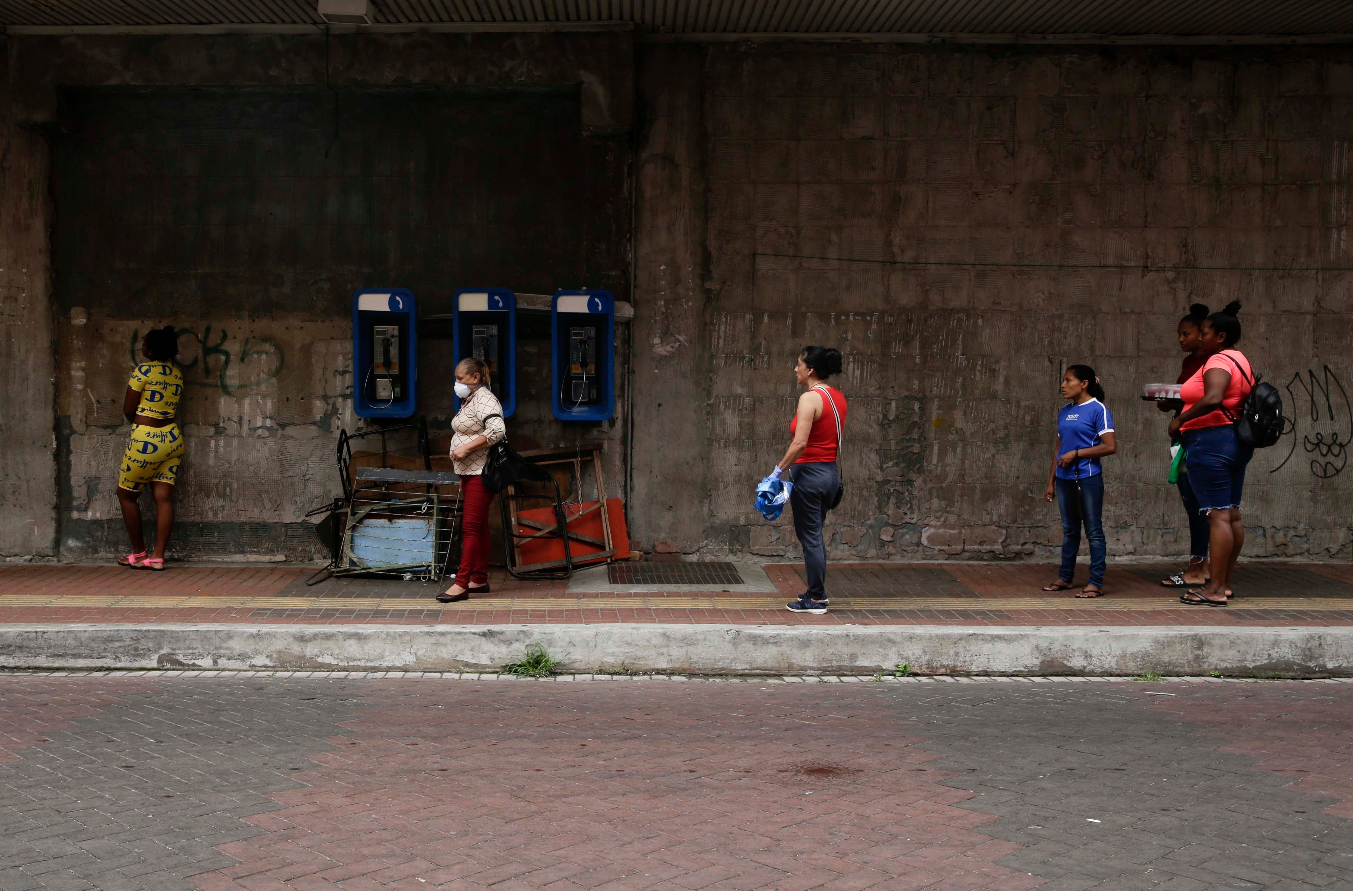 Women practice social distancing as they wait in line to enter a supermarket, on a day that men must stay indoors in Panama City on April 3, 2020.