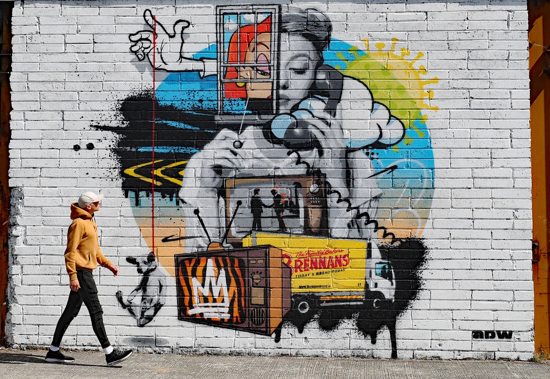 A man walks past a street art mural by the artist ADW in County Laois, Ireland, May 30, 2020. Entitled "Is it Still raining? I hadn't noticed", the work deals with the issue of mental health during the Covid-19 lockdown.