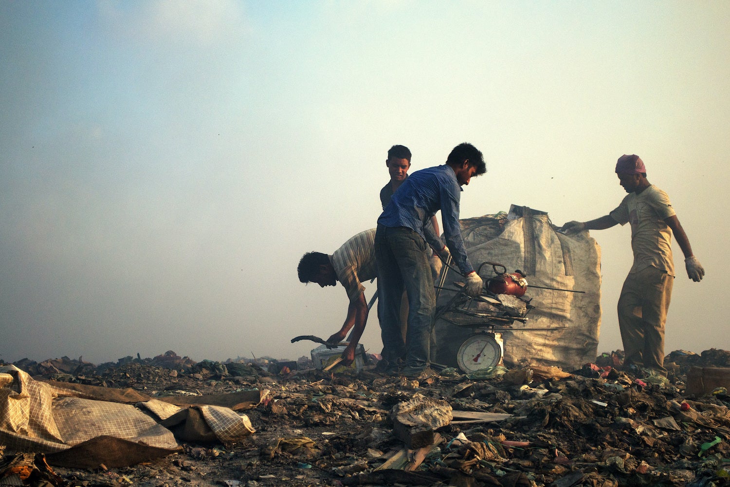 Migrant workers weigh scrap metal, Thilafushi, Maldives.
