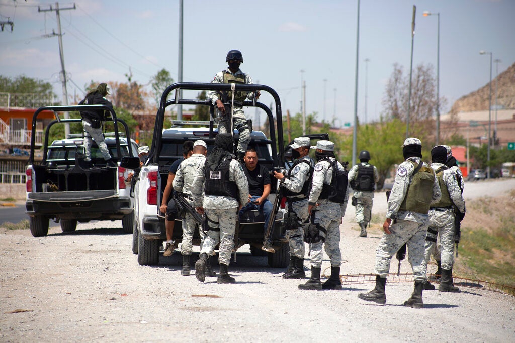 Mexican National Guard members arrest a migrant who tried crossing the Río Bravo in Ciudad Juárez,