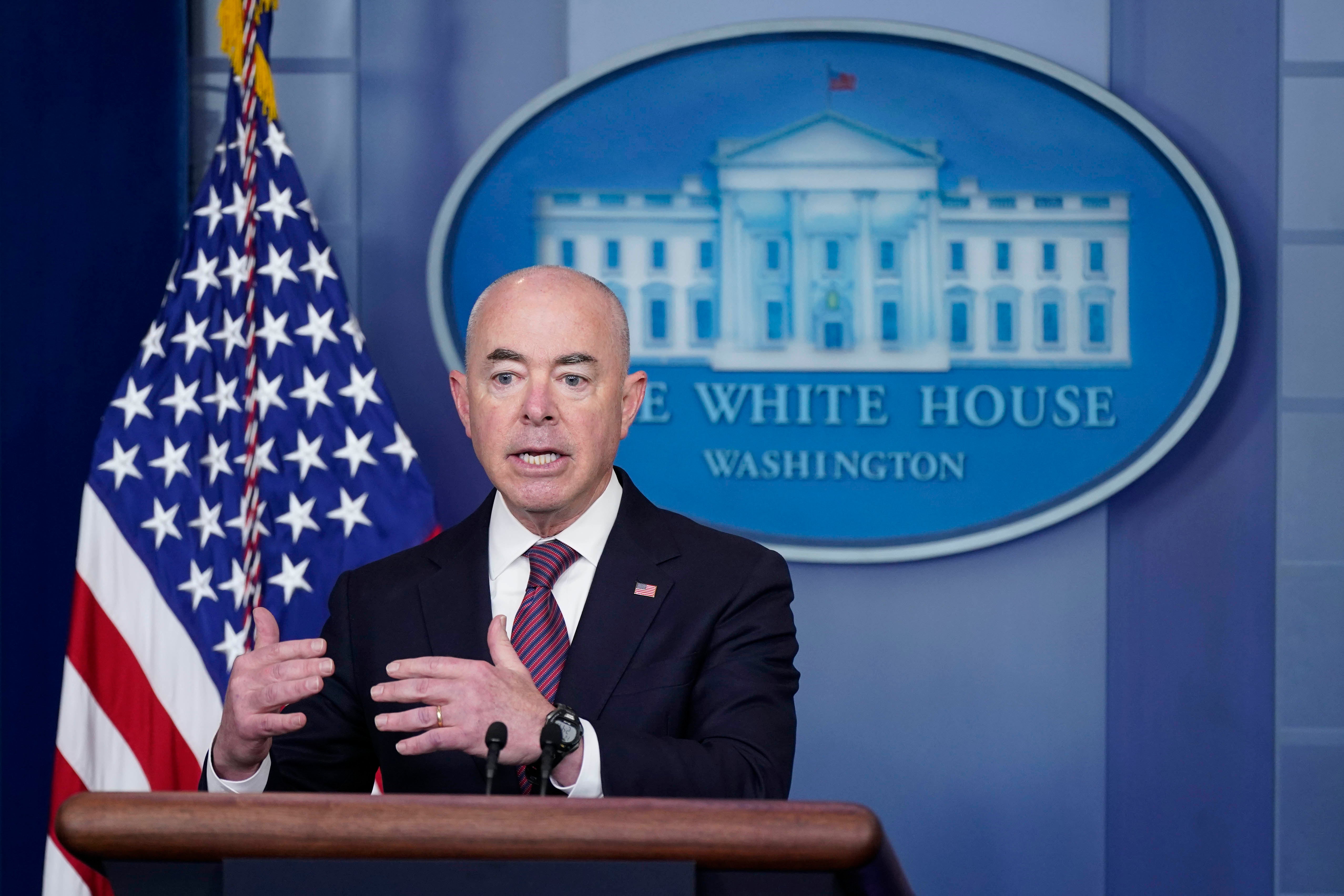 A man stands in front of a podium with the White House emblem behind him