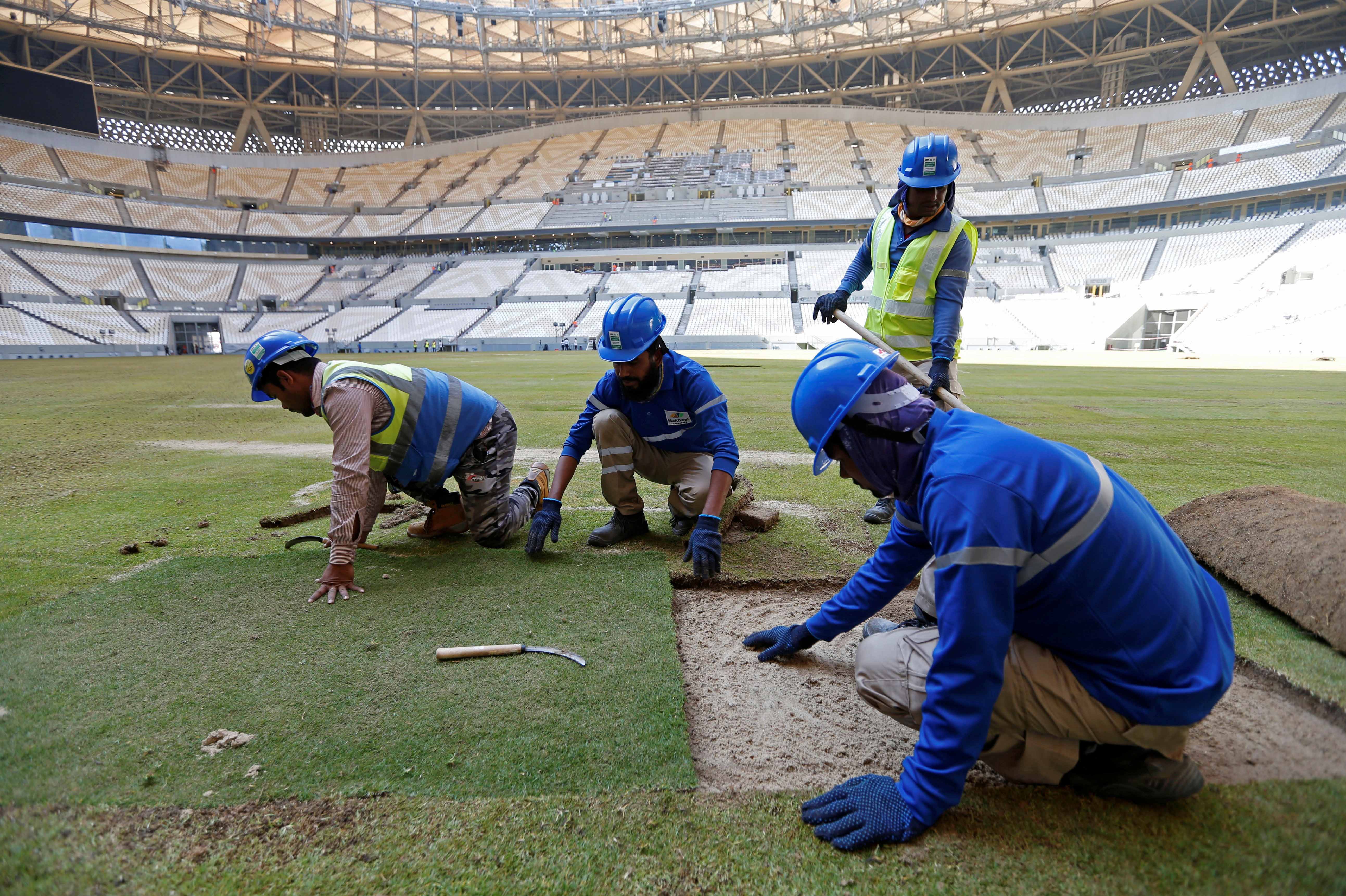  Workers lay the turf inside the Lusail Stadium, the venue for the 2022 Qatar World Cup final, in Lusail, Qatar, November 18, 2021.