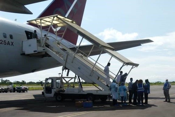 People walk down a ramp off of an airplane