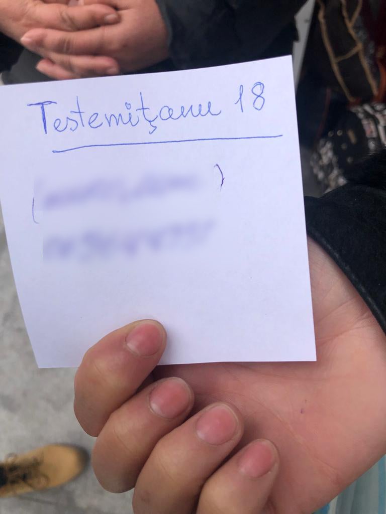 Maria holding a piece of paper on which MoldExpo staff had written the address and phone number of FRISPA center.