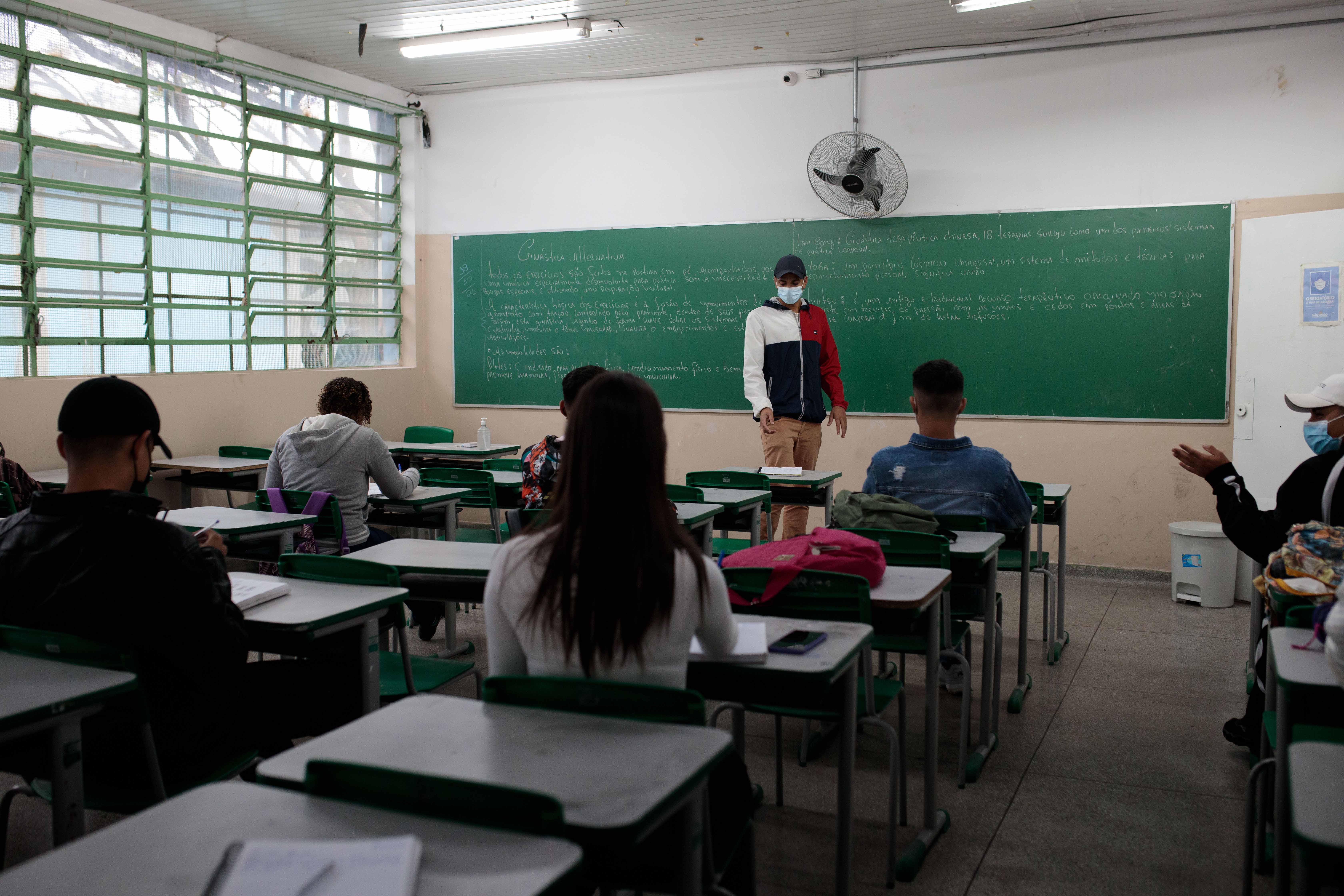 A teacher stands in front of a classroom of students