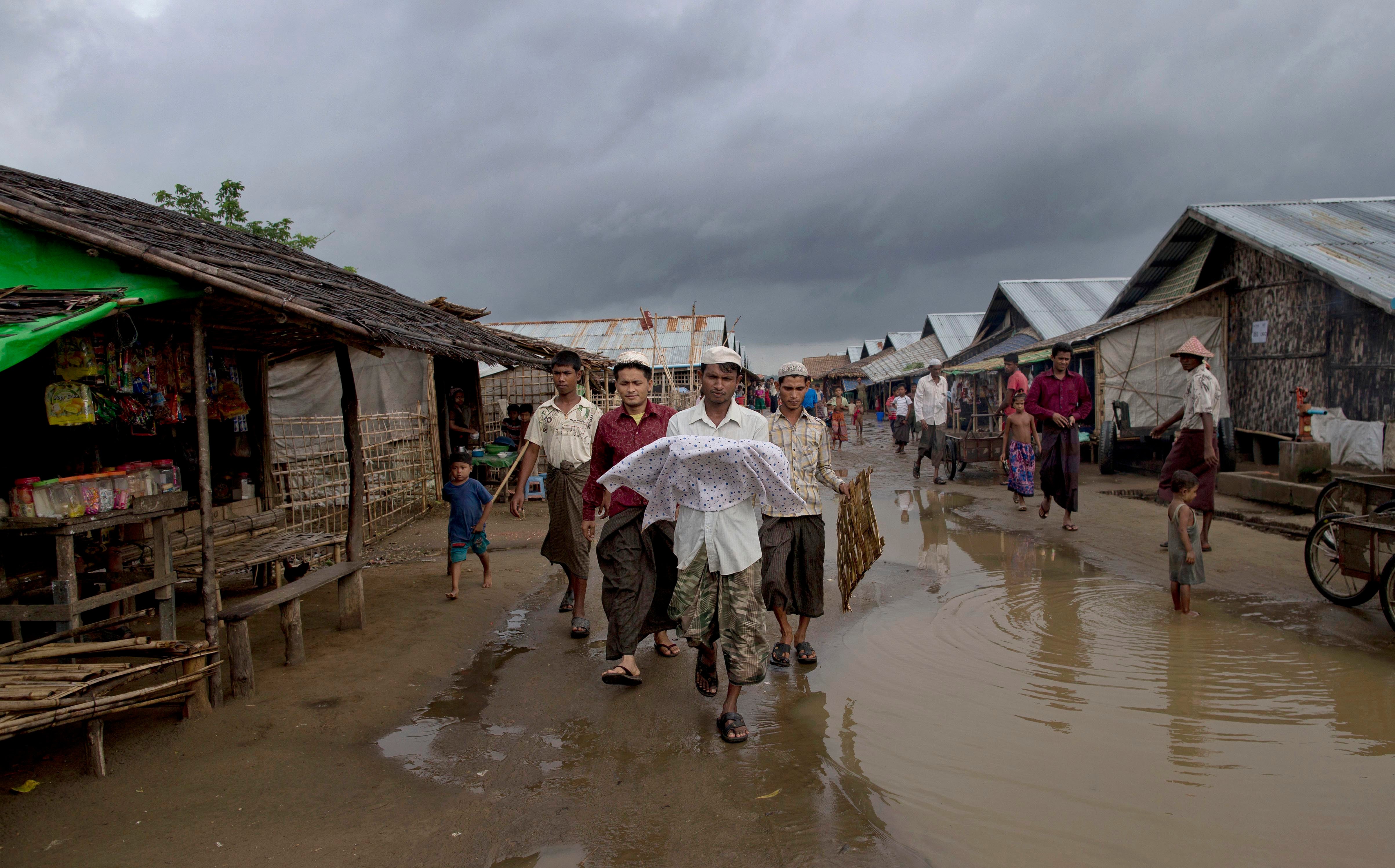 A Rohingya man carries the body of his niece
