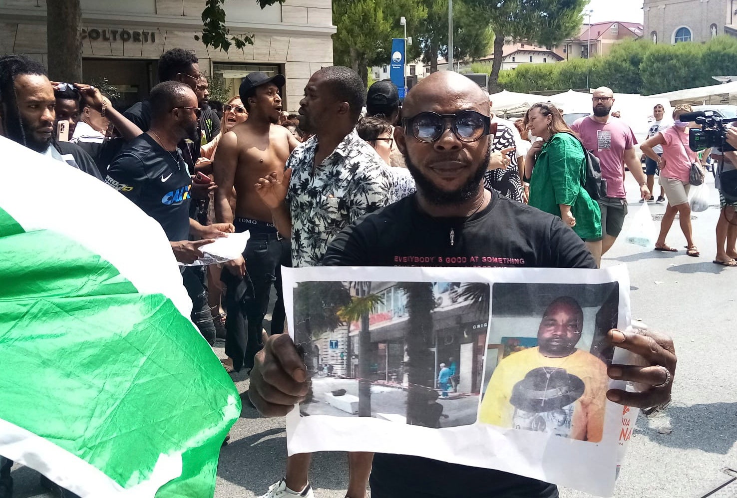 A man shows a picture of the victim Nigerian street vendor Alika Ogorchukwu