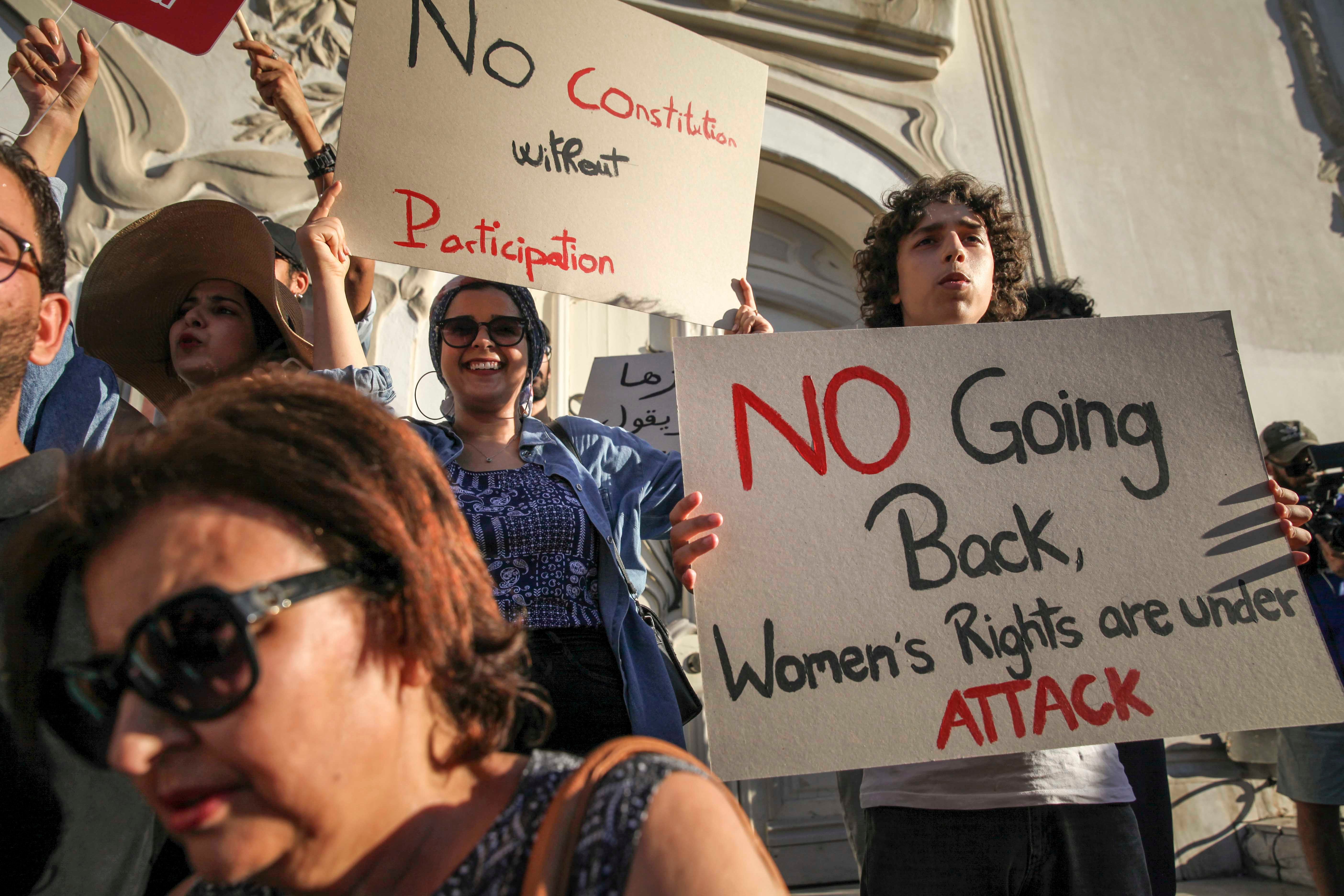 A Tunisian protester holds up a sign that reads, “No going back, women's rights are under attack,” during a protest against president Saied on Avenue Habib Bourguiba in Tunis, on July 22, 2022.