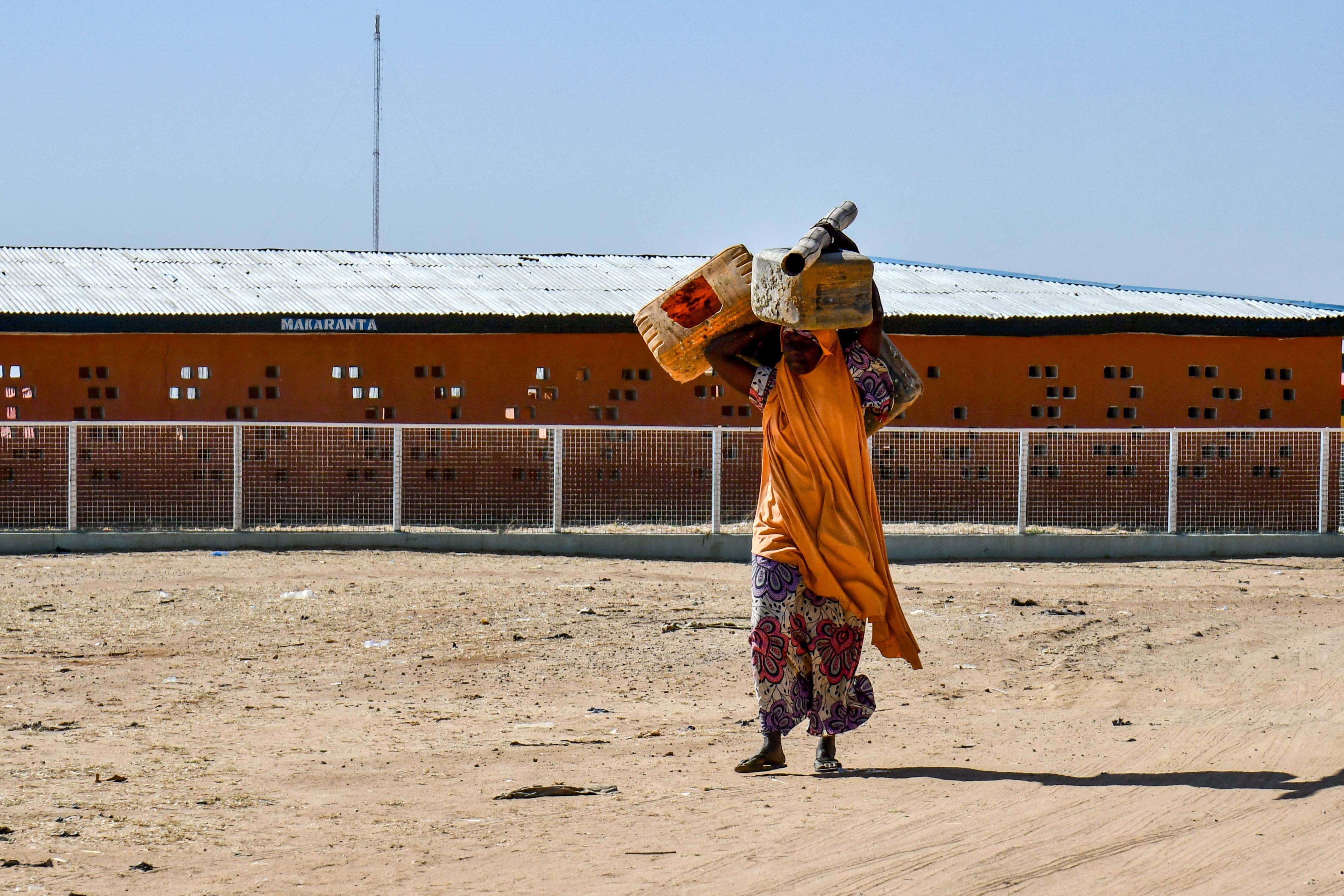 A woman carries belongings over her head