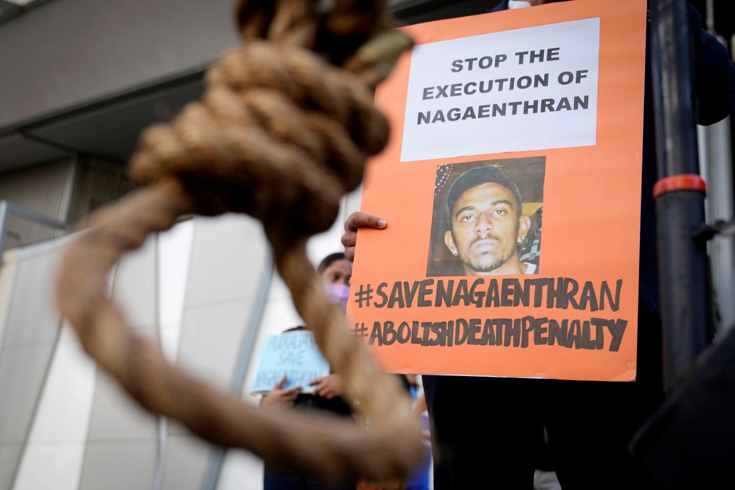 An activist holds a poster opposing the impending execution of Nagaenthran Dharmalingam