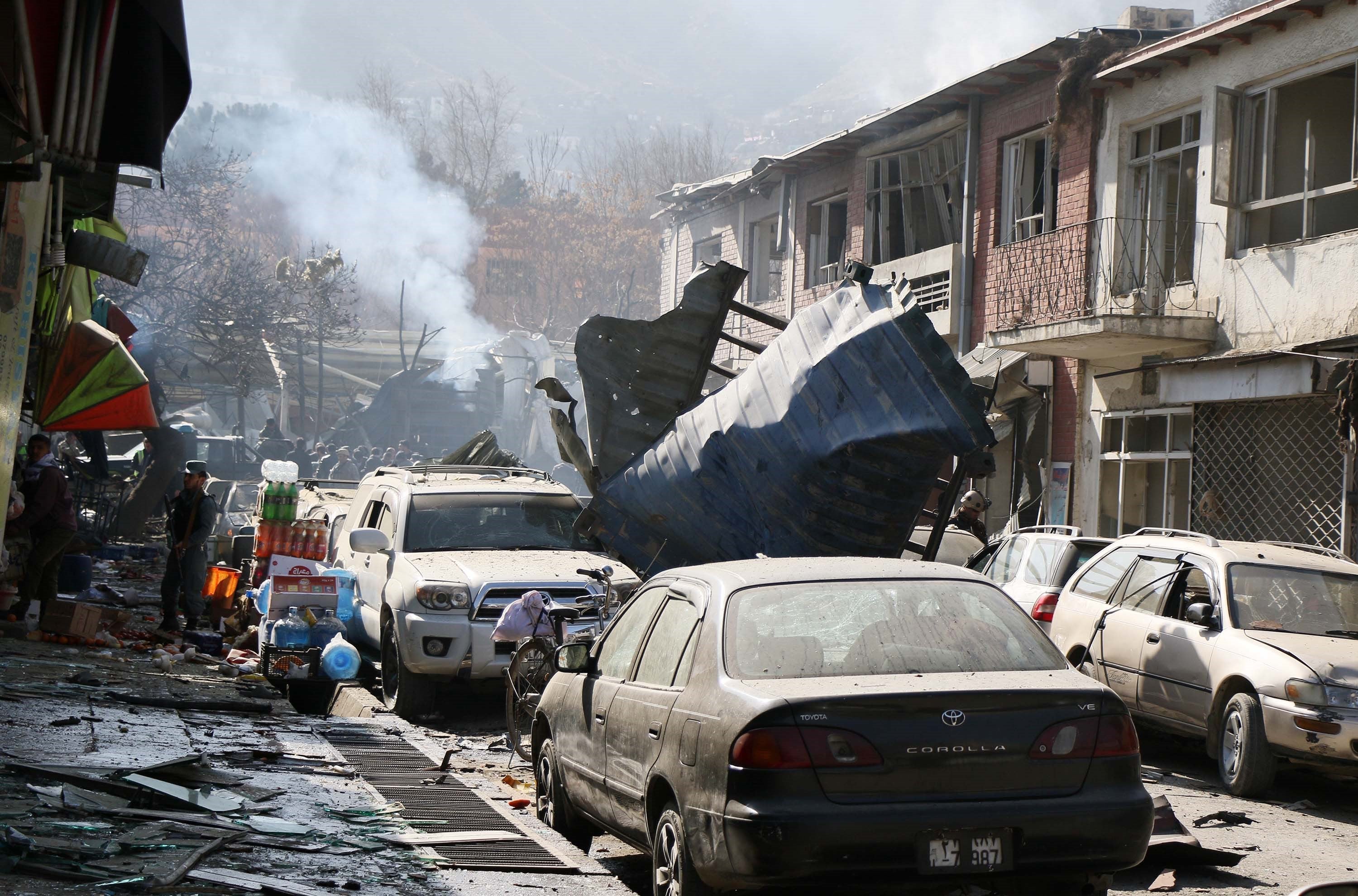 Afghan security officials inspect the site of a Taliban suicide bombing in Kabul.