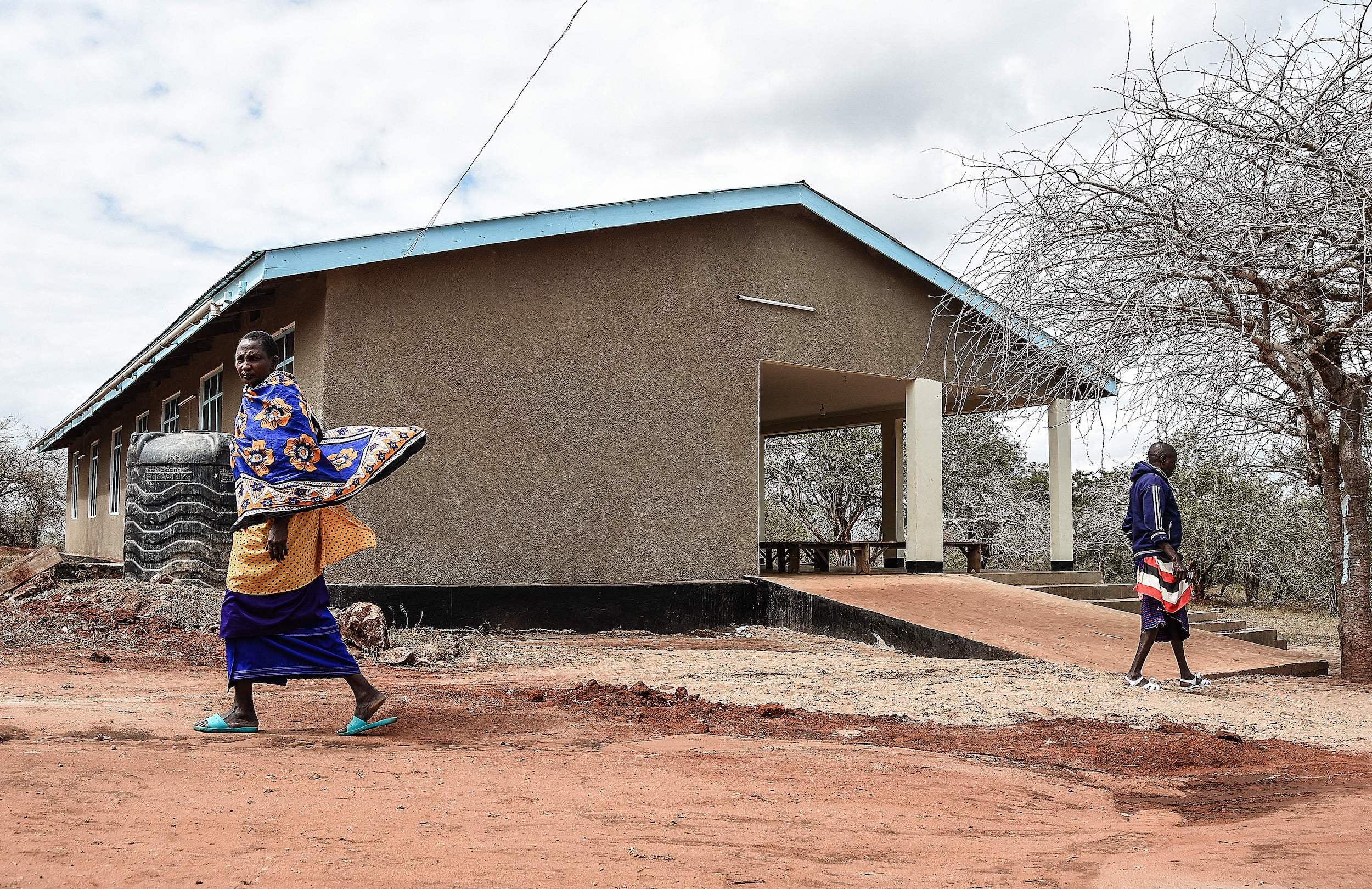 Maasai people walk past the health facility in Msomera village, Handeni, Tanzania.