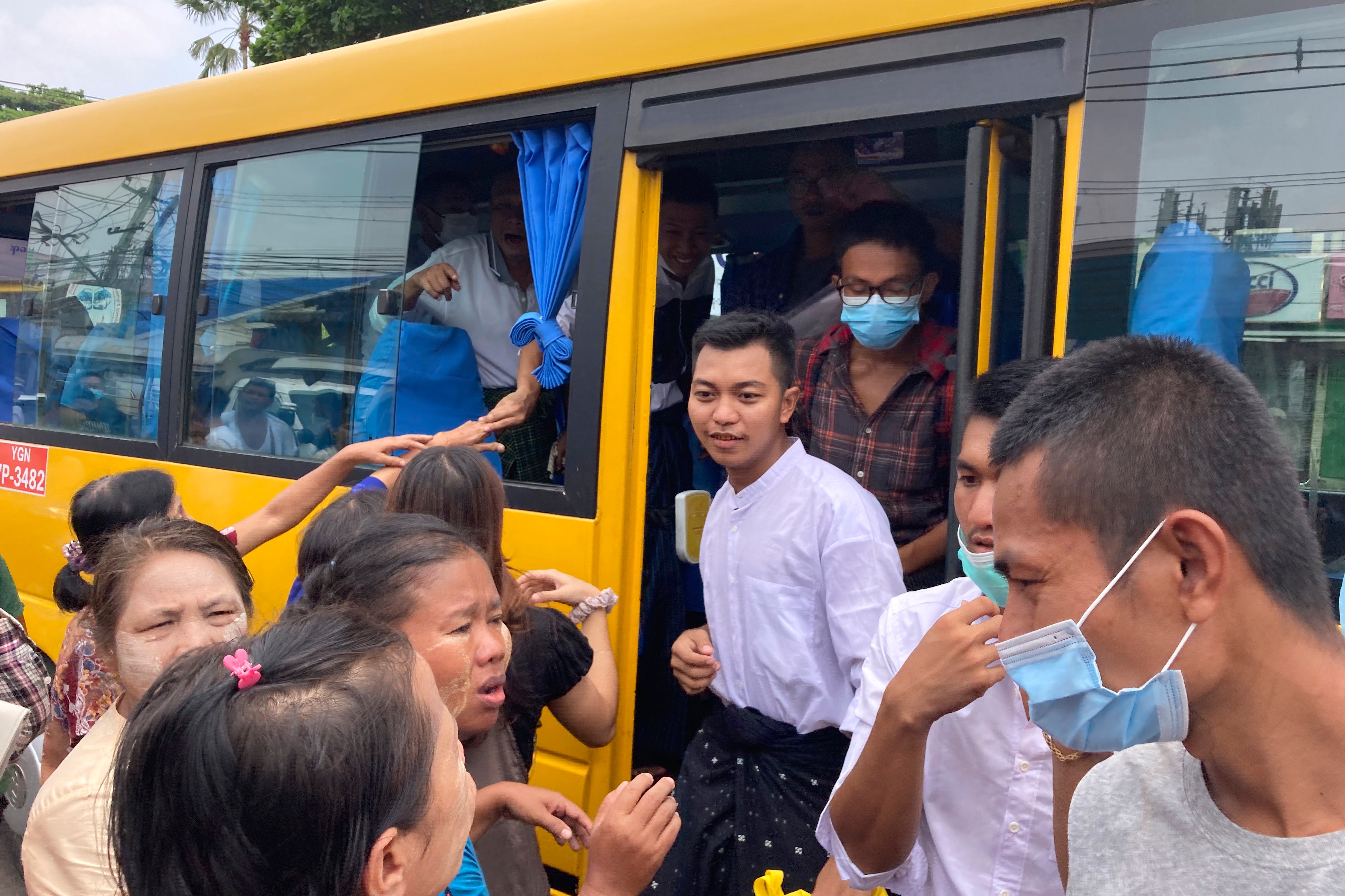 Prisoners get off a bus after their release from Insein Prison