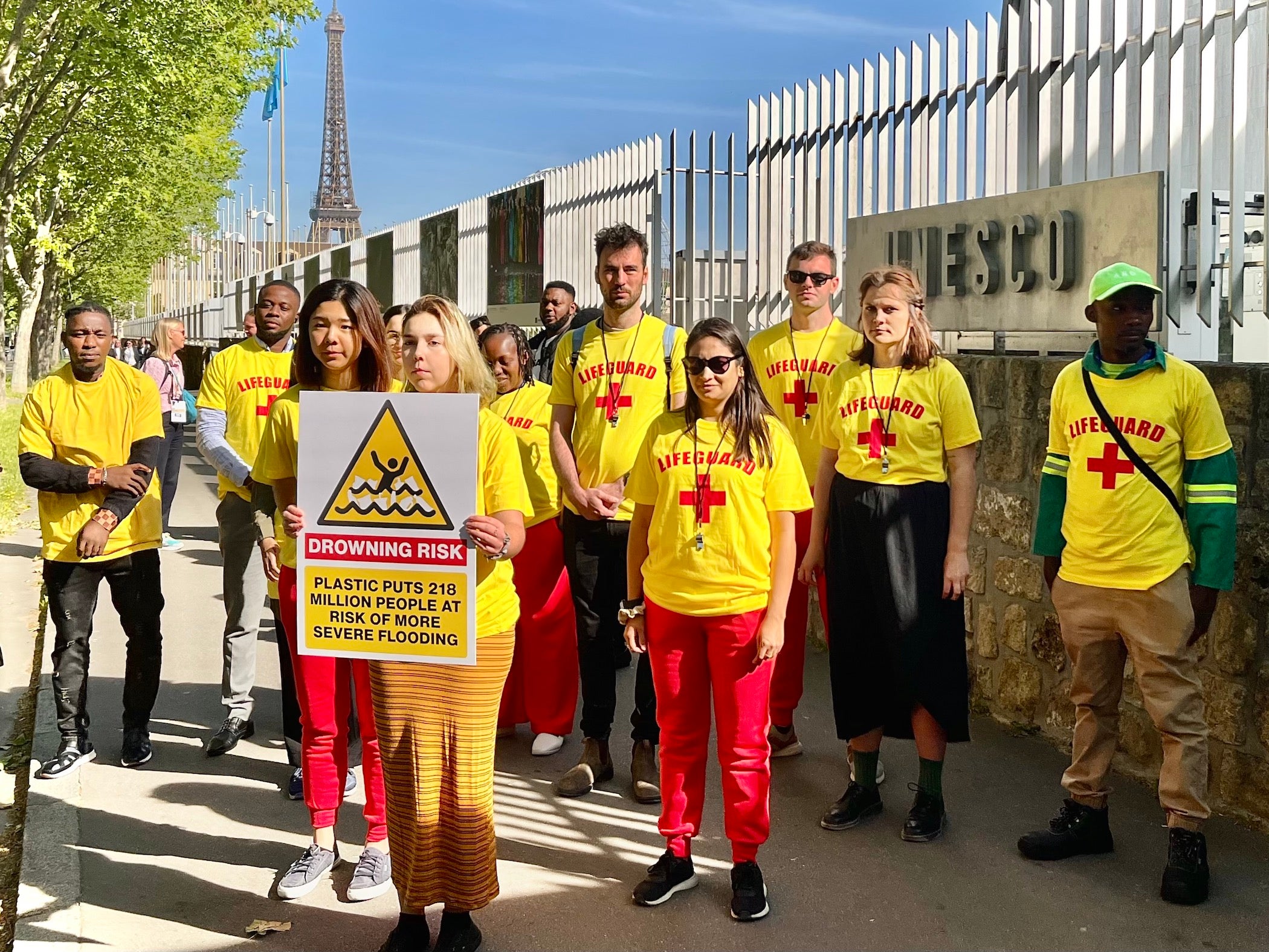 Campaigners and waste pickers from around the world holding a sign reading, “plastic puts 218 million people at risk of more severe flooding,” outside the UNESCO Headquarters in Paris, where the second round of plastics treaty negotiations took place, May 30, 2023.