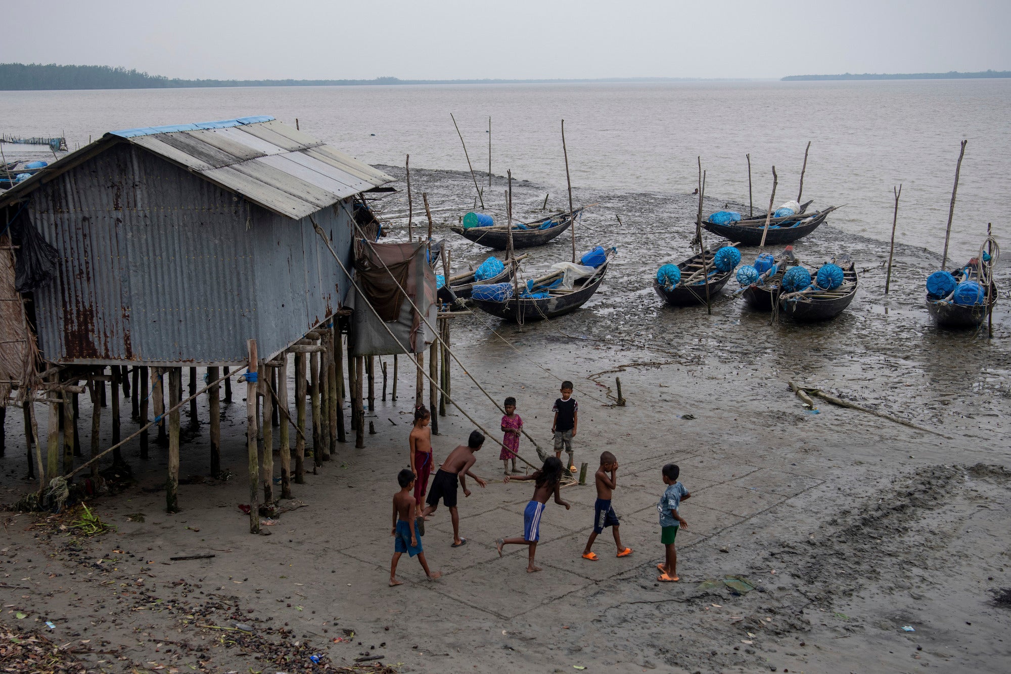 Children playing along the broken bank of the Shibsha River at Dakop Upazilla, Khulna, Bangladesh, August 26, 2023. 