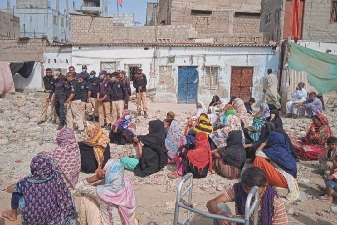 Women protest their eviction at a stormwater drain