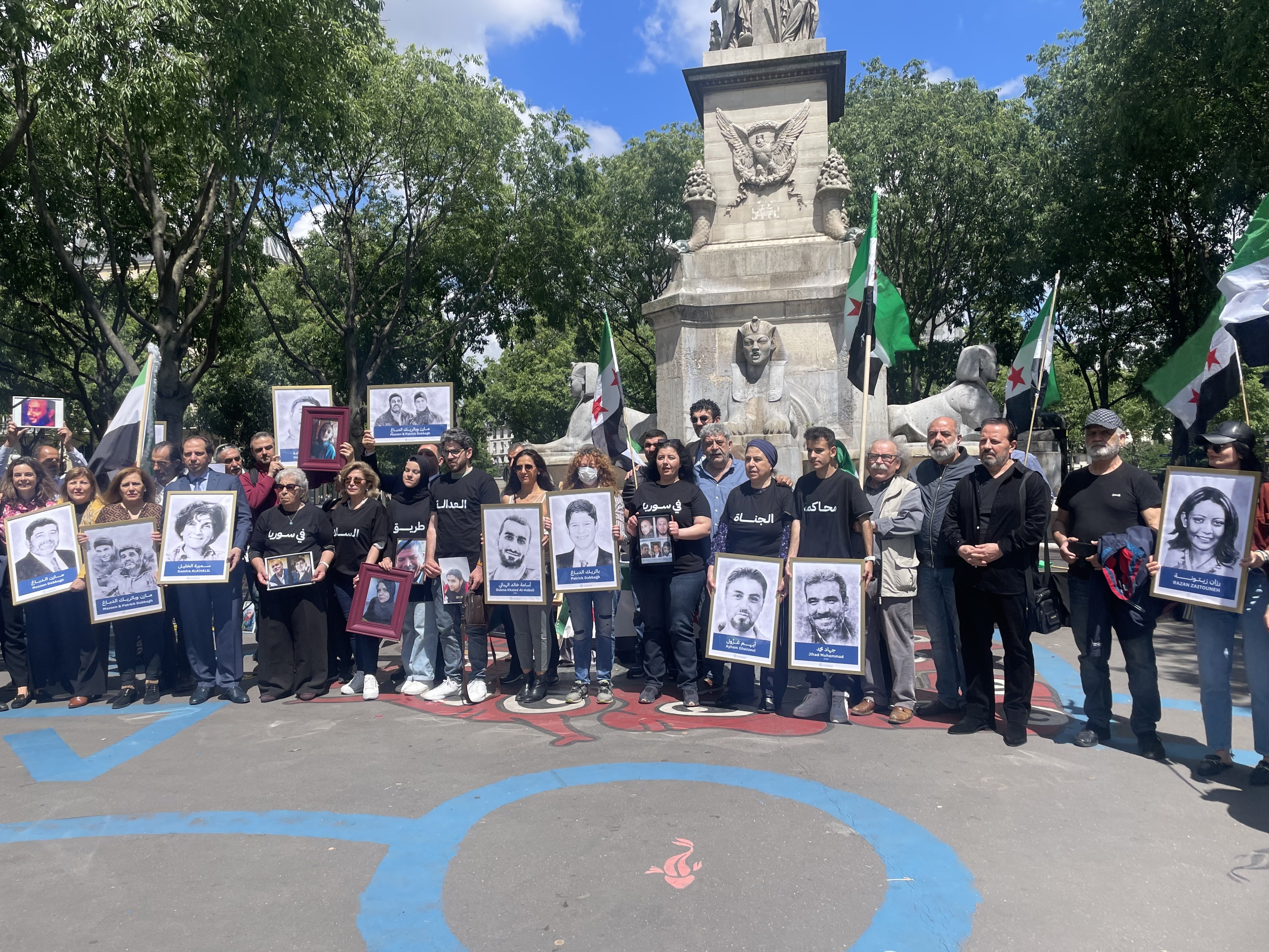 Victims’ and families’ associations gathered next to the Paris Criminal Court on May 21, 2024, holding photos of relatives who have been detained or disappeared in Syria