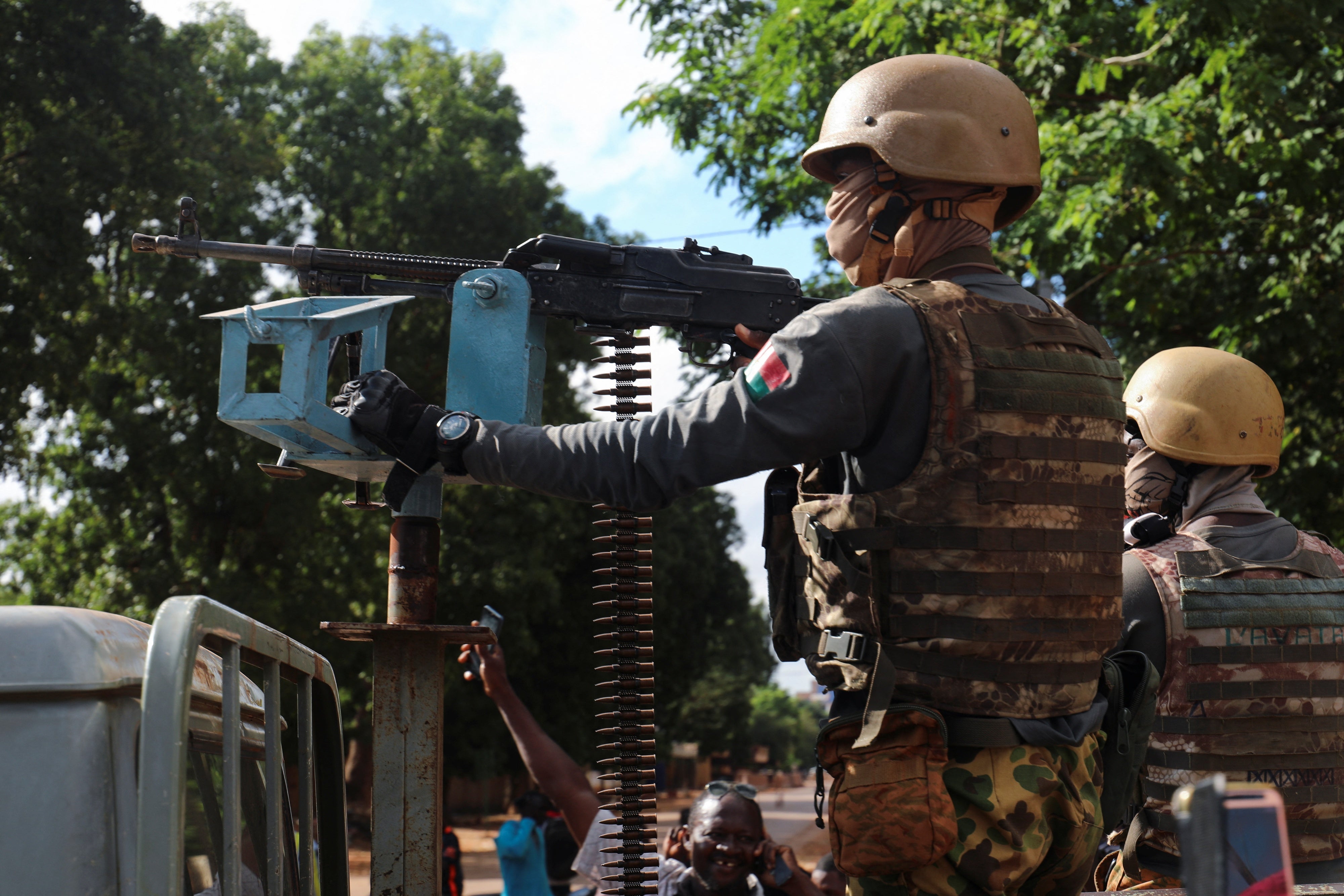 A Burkina Faso soldier stands guard in armored vehicle