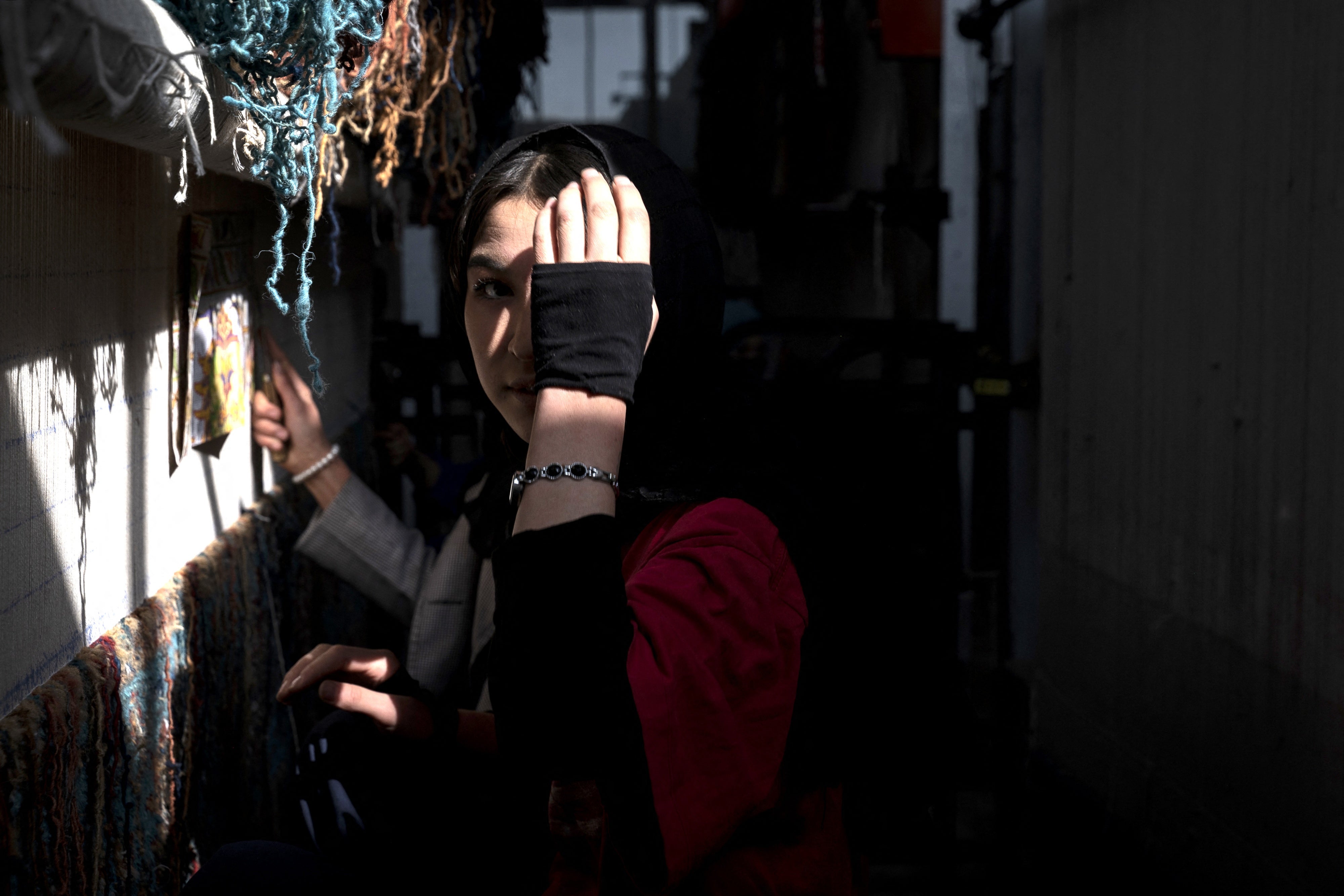 Une femme afghane tisse un tapis dans une usine à la périphérie de Kaboul, Afghanistan, 11 novembre 2024.
