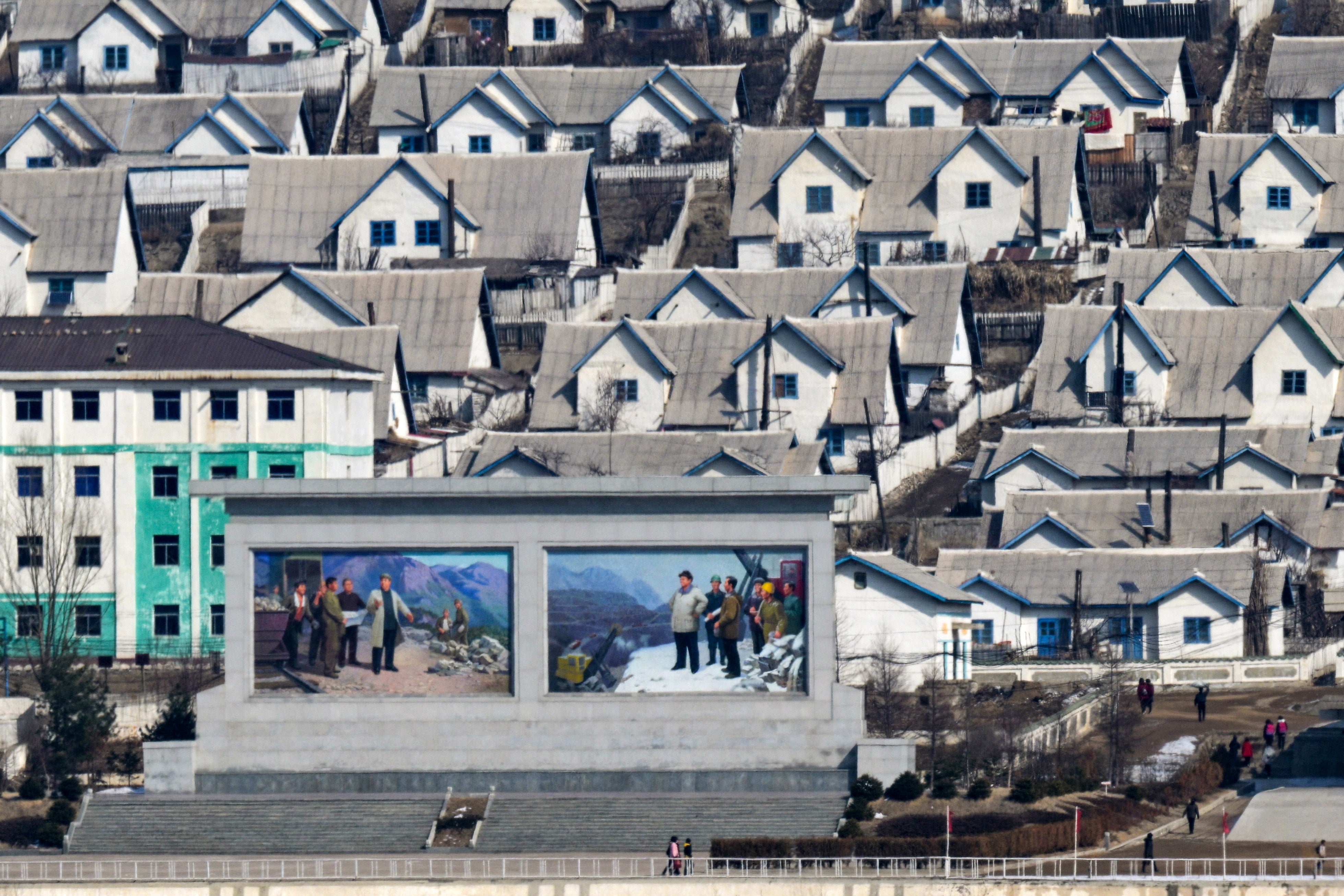 Rows of houses and a billboard in North Korea.