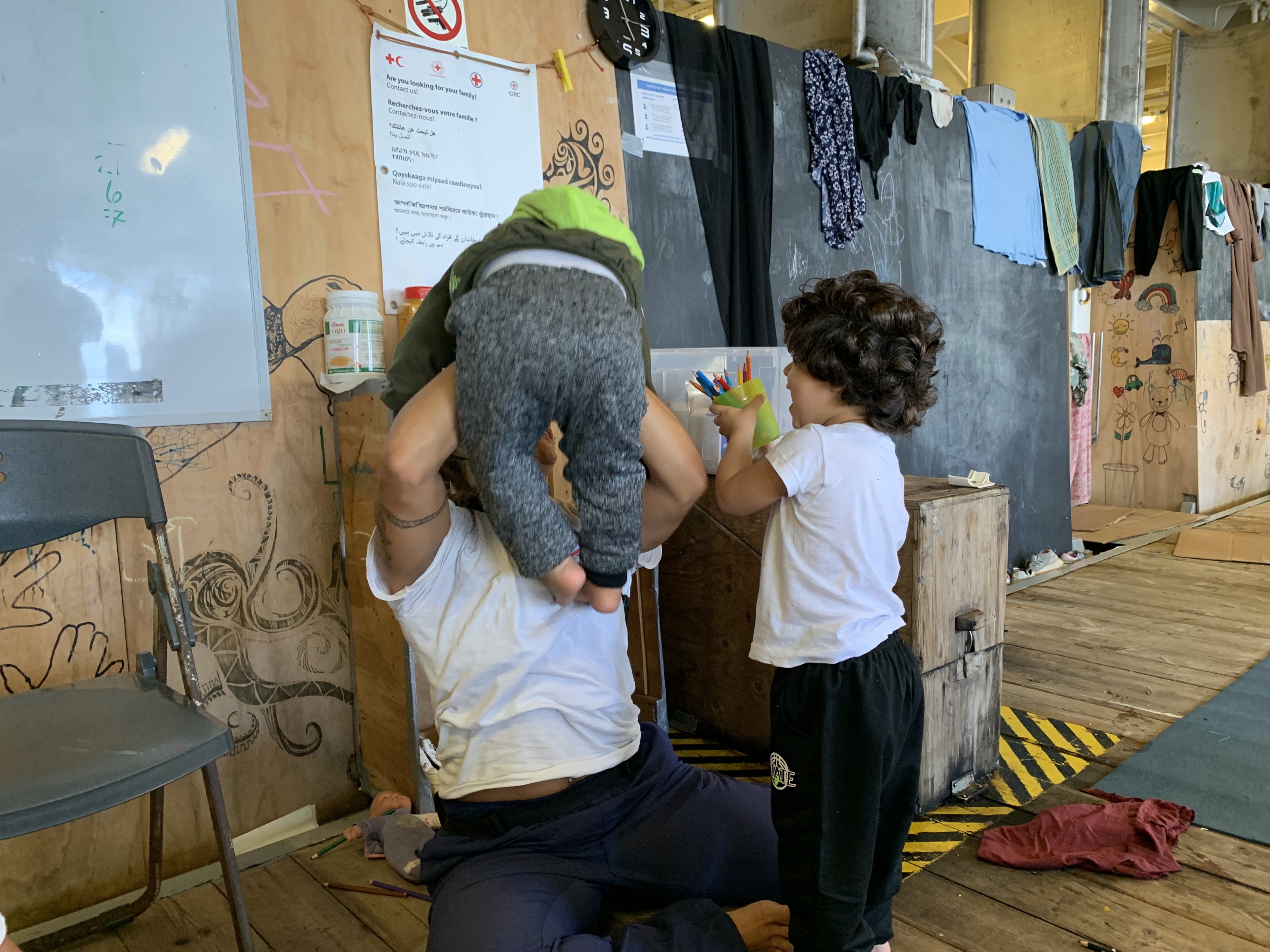 An MSF rescue crewmember plays with children in the women’s “streamer shelter” on the Geo Barents, September 21, 2024. 