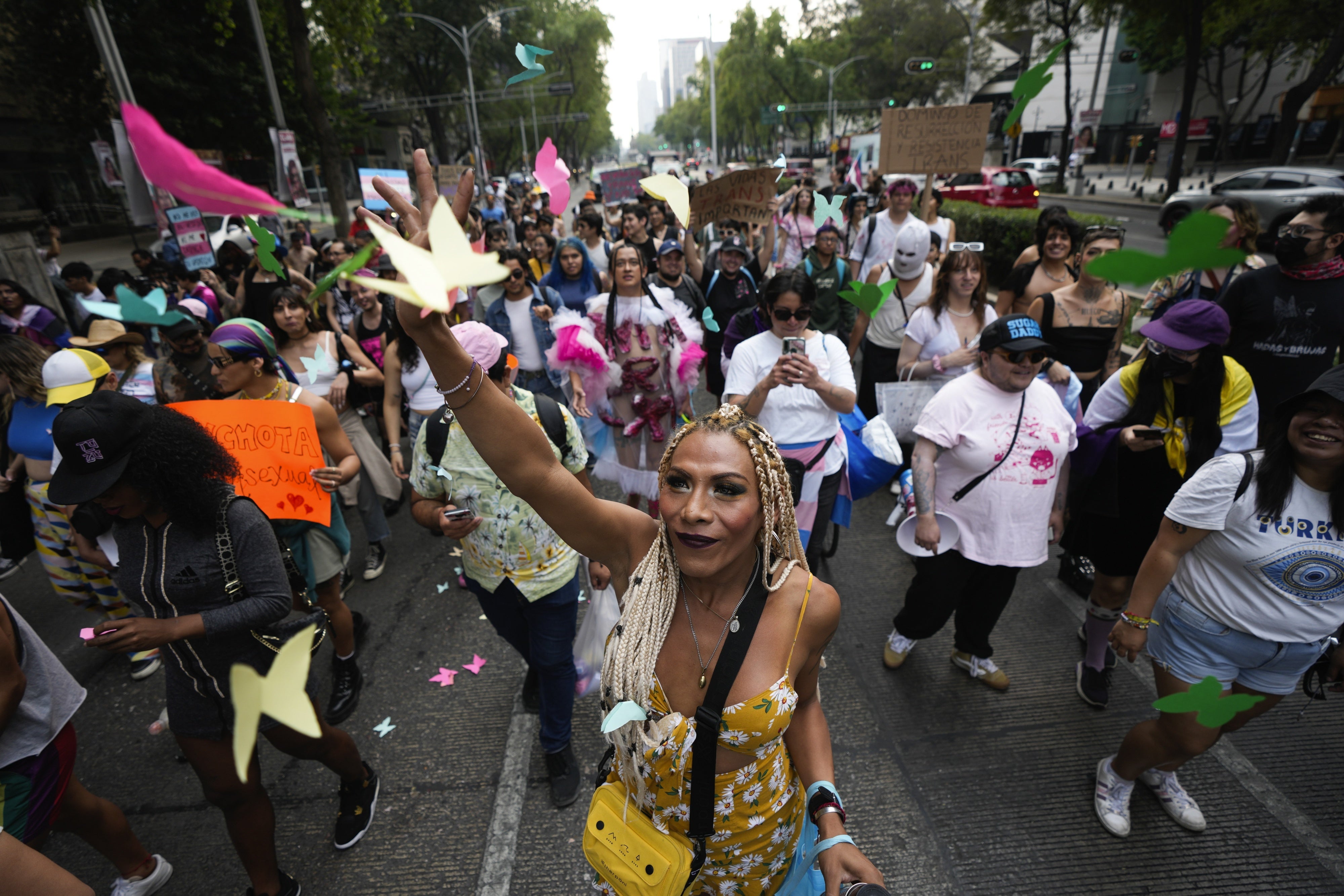 A demonstrator throws colored papers shaped like butterflies during a protest