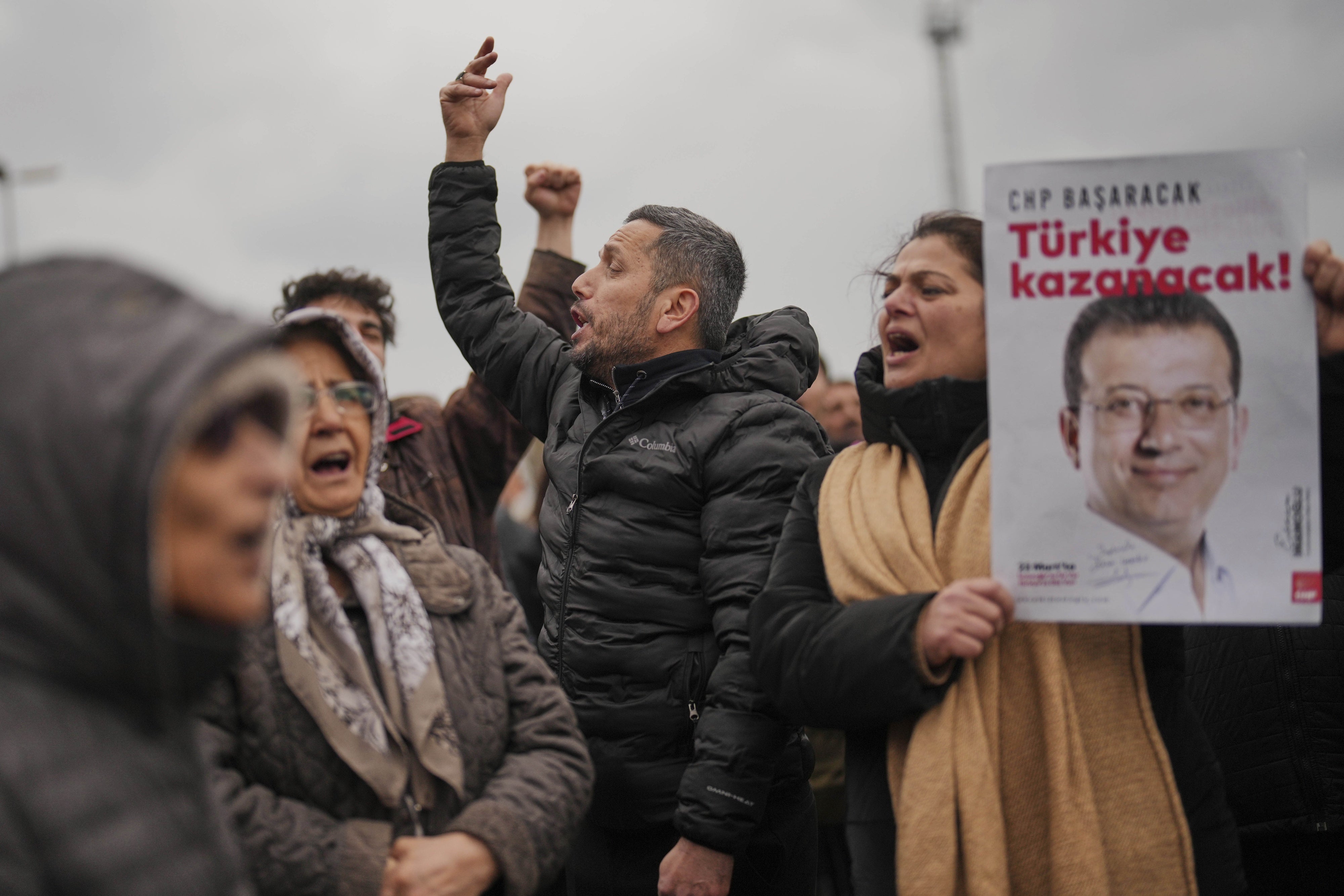 People hold posters of Istanbul Mayor Ekrem İmamoğlu as they protest outside the Vatan Security Department, where İmamoğlu is expected to be taken following his arrest in Istanbul, Türkiye, March 19, 2025. 