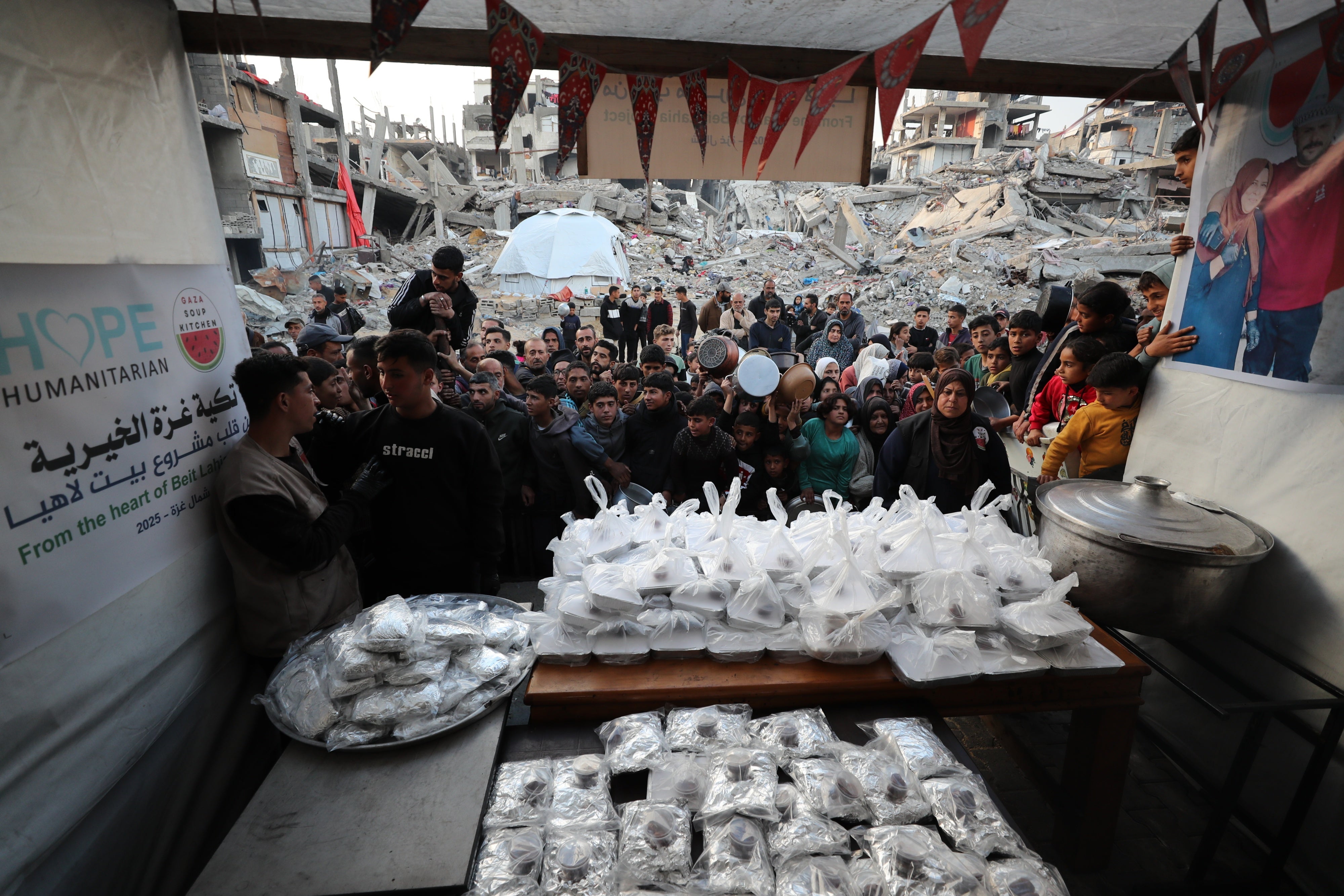 Palestinians wait in line to receive hot food at Jabalia refugee camp in Gaza on March 4, 2025.