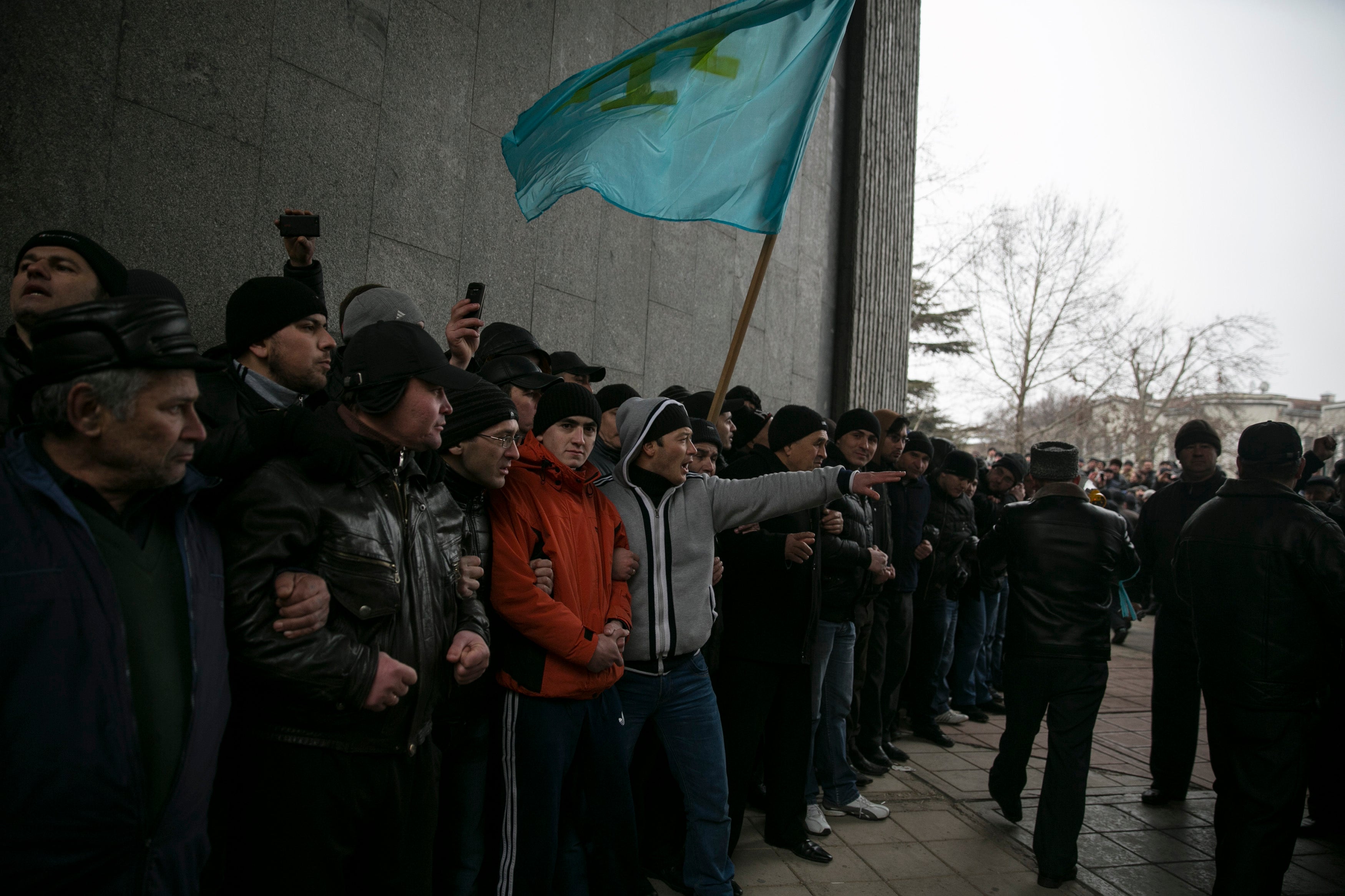 Crimean Tatars holding their flag during rallies near the Crimean parliament building on February 26, 2014, in the early days of Russia’s invasion of Crimea. 