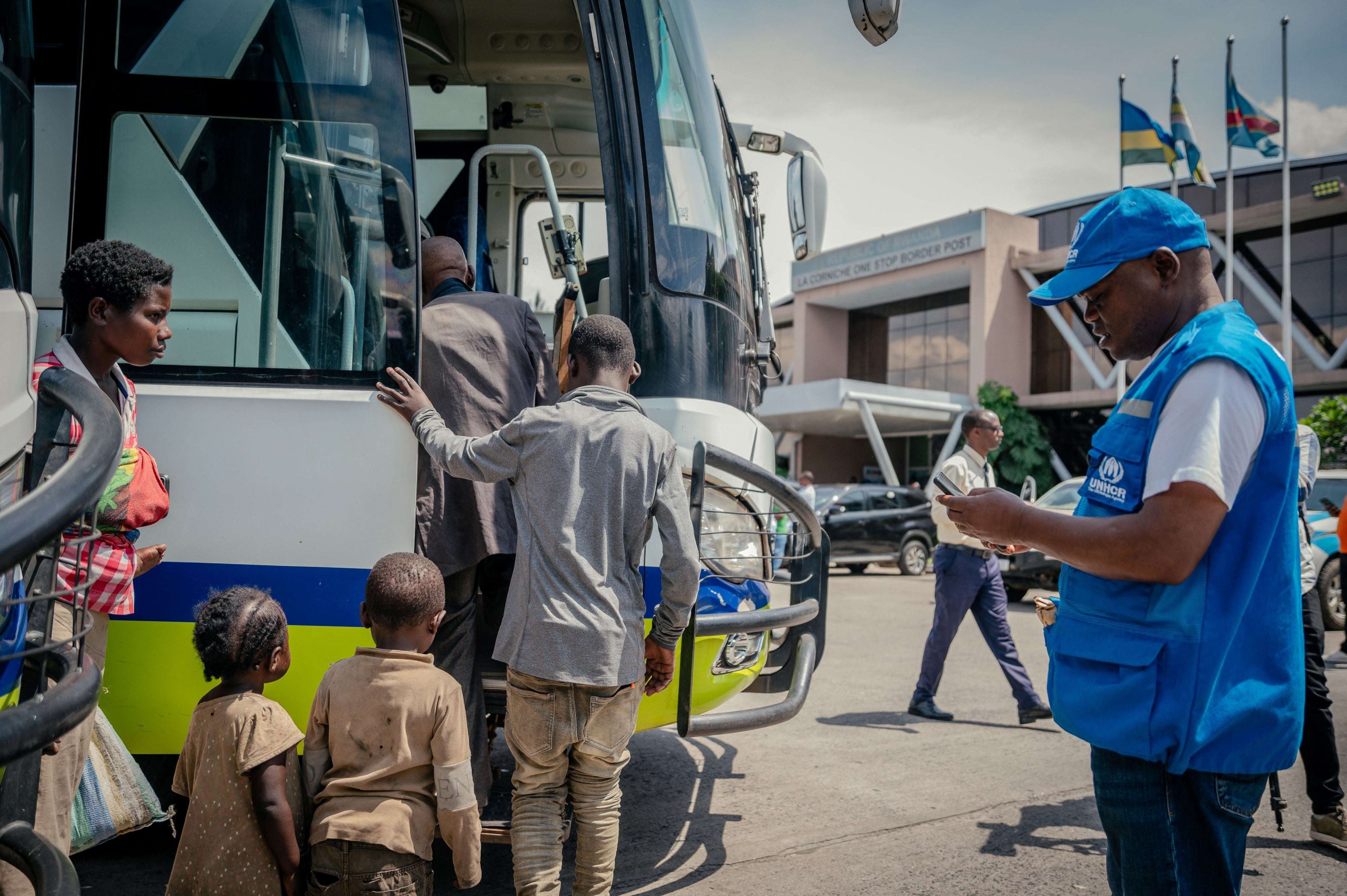 Displaced people board a bus after undergoing checks at the border between the Democratic Republic of Congo and Rwanda