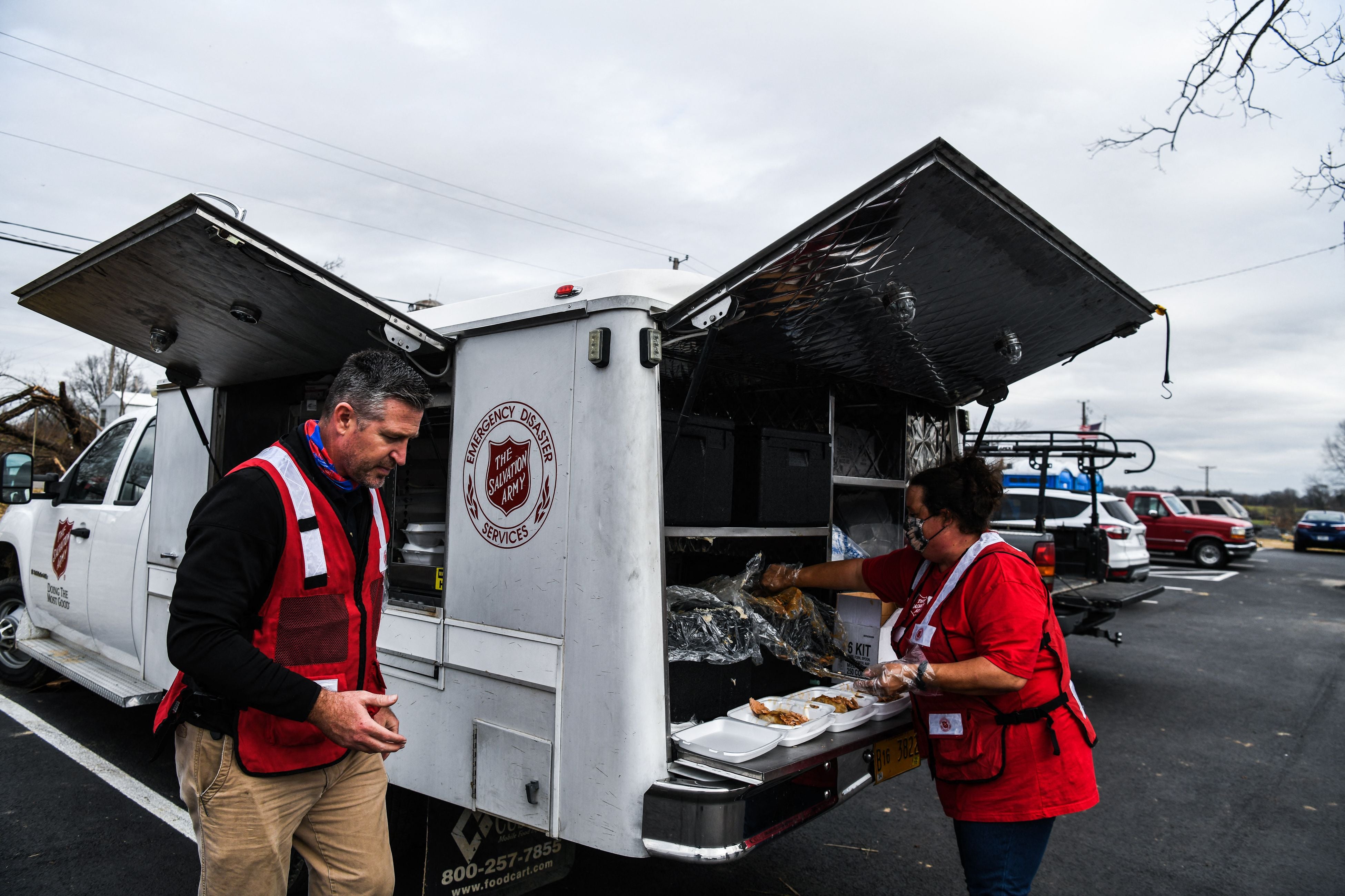 Director of Divisional Emergency Response of the Salvation Army William Trueblood (L) distributes food outside the Cayce United Methodist Church in Cayce, Kentucky, US, December 15, 2021, five days after tornadoes hit the area. 