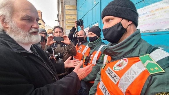 Pastor Gábor Iványi of the Hungarian Evangelical Fellowship speaks with National Tax and Customs officials during an armed raid on his church’s center in Budapest, Hungary on February 21, 2022. 