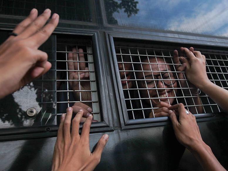 Student activists are taken from the Bangkok military court to prison after being arrested and charged for holding anti-coup protests on June 26, 2015.