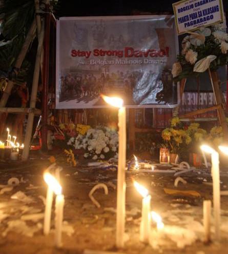 Candles are lit at a memorial site for the victims of the September 2, 2016 explosion in a market in Davao City, Philippines. 