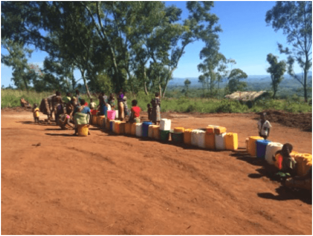 Women and girls at one of the two only borehole wells at the crowded Kapise camp in Malawi that is now serving over 6000 people. 