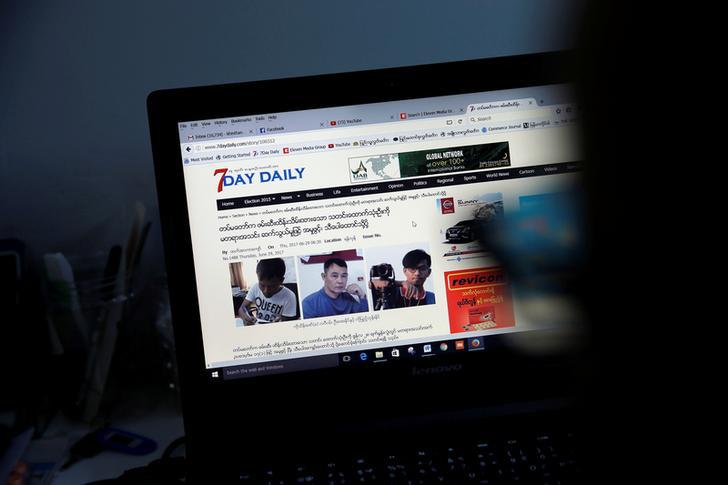 A reporter looks at an article about the three detained journalists in the Democratic Voice of Burma newsroom in Rangoon, Burma, June 29, 2017.