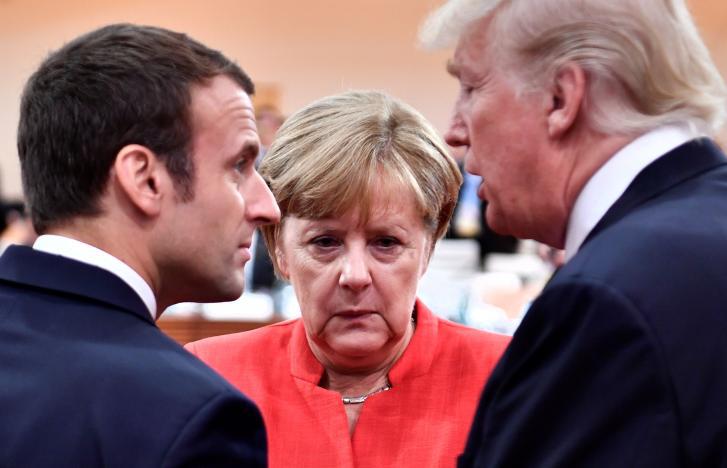 French President Emmanuel Macron, German Chancellor Angela Merkel and U.S. President Donald Trump confer at the start of the first working session of the G20 meeting in Hamburg, Germany, July 7, 2017.