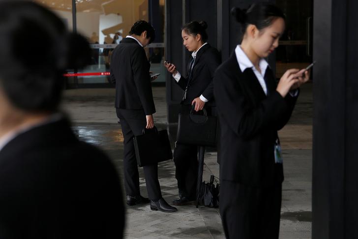 People check their phones during the World Internet Conference in Wuzhen, China, November 17, 2016. 