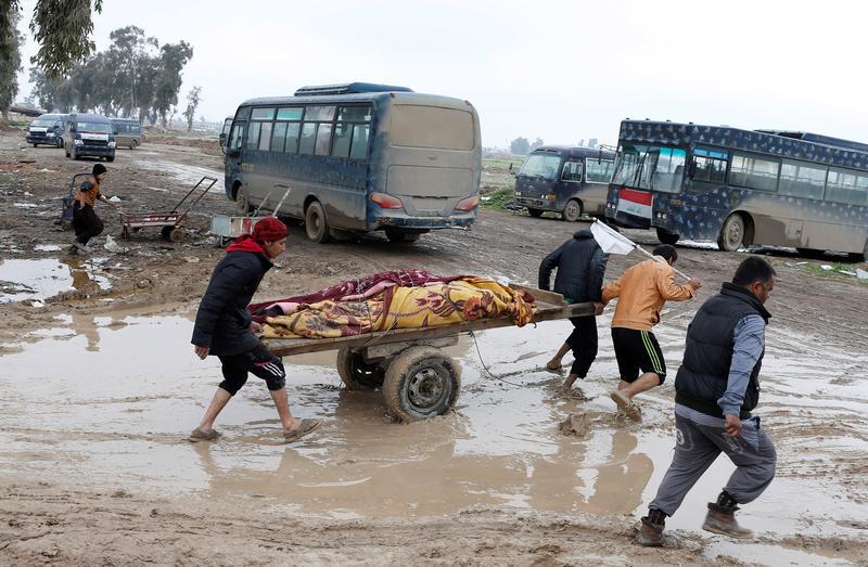 Relatives carry the bodies of civilians killed in an attack in New Mosul neighborhood of west Mosul on March 17, 2017. © 2017 Reuters