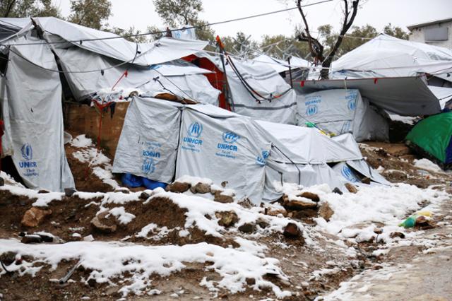 Snow lays next to tents provided by the UNHCR at the refugee camp of Moria on the Greek island of Lesbos, January 10, 2017.
