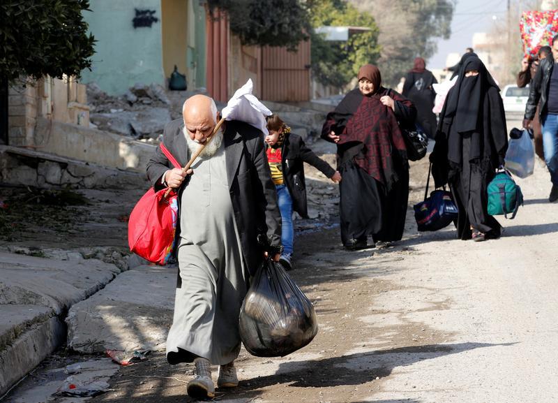 Civilians, who fled from clashes, walk in the street during a battle with Islamic State militants, in Sukar neighborhood east of Mosul, Iraq, January 11, 2017. REUTERS/Ahmed Saad