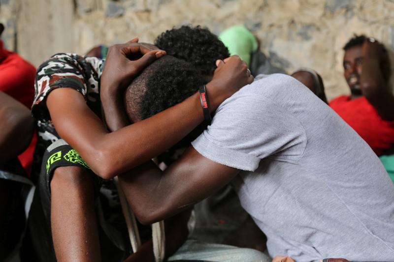 Somali refugees who survived an attack on a boat off Yemen's coast in the Red Sea hug each other as they sit at a detention center in the Houthi-held port of Hodeidah, Yemen, March 22, 2017. 