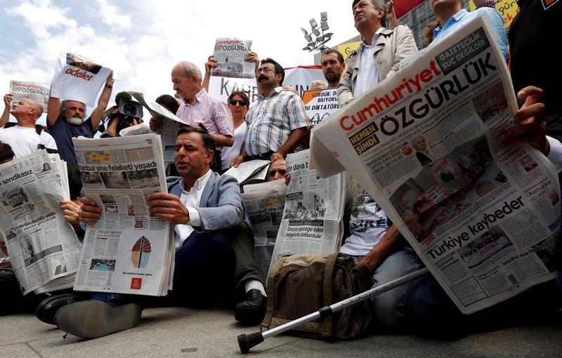 Press freedom activists read opposition newspaper Cumhuriyet during a demonstration in solidarity with the jailed members of the newspaper outside a courthouse, in Istanbul, Turkey, July 28, 2017. 