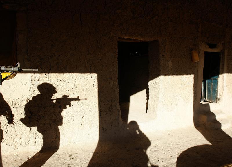 A US soldier searches a house in a village in Baluchi pass in Uruzgan province, November 1, 2004.