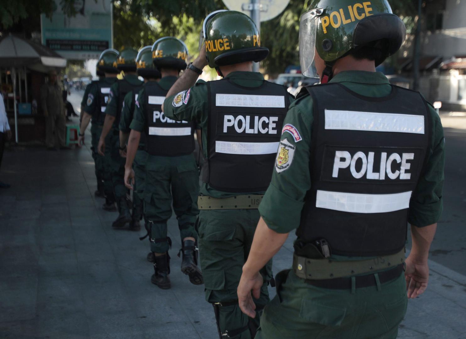 Riot police walk toward their positions to block supporters of the opposition Cambodia National Rescue Party marching toward an appeals court in Phnom Penh, Cambodia, Tuesday, Sept. 26, 2017. 