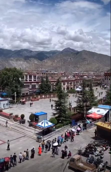 People line up at a checkpoint controlling access to Barkor Square in front of the Jokhang temple in center city Lhasa.