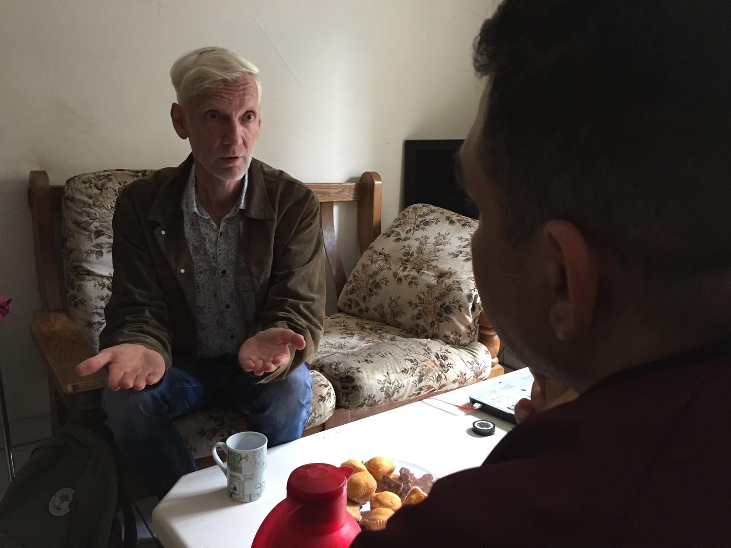Two men sitting in a room and talking
