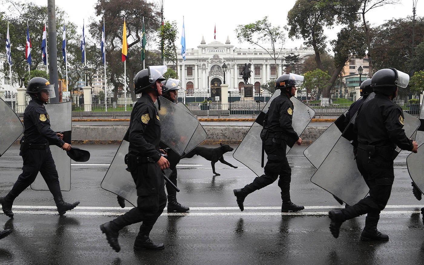 Riot police walk in front of the closed congress building in Lima, Peru, Tuesday, Oct. 1, 2019. 
